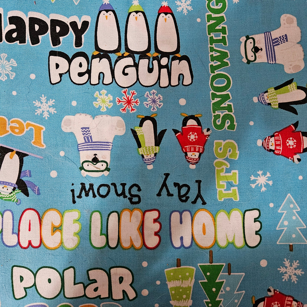  winter-themed dog bandana featuring penguins, snowflakes, and text on a blue background.